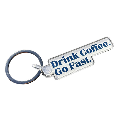 Keychain with 'Drink Coffee Go Fast' text on a white background